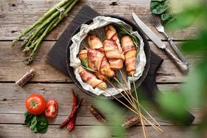 Roll with bacon and chicken mince on a stew with fresh asparagus photo