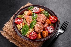 Delicious fresh pasta with meatballs, sauce, cherry tomatoes and basil photo