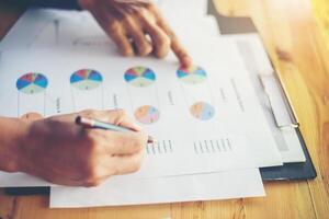 Manos de mujer de negocios trabajando en teléfonos inteligentes e información comercial foto