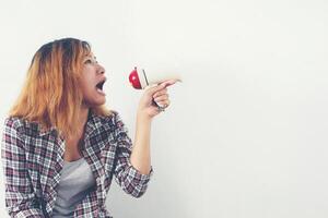 mujer joven inconformista gritando por megáfono. foto