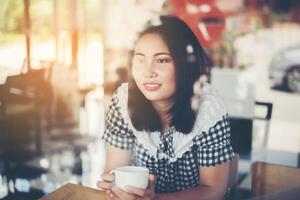 Beautiful woman sitting and drinking coffee at cafe. photo