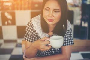 Beautiful woman sitting and drinking coffee at cafe. photo