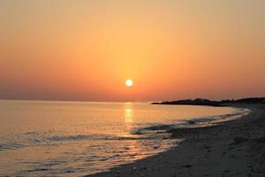 hermosa puesta de sol naranja sobre una playa tropical. foto