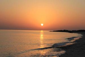 Beautiful orange sunset over a tropical beach. photo