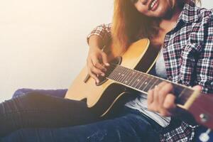 mujer joven inconformista tocando una guitarra. foto