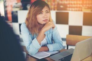 Hipster woman with her hands on her chin thinking with seriousness photo