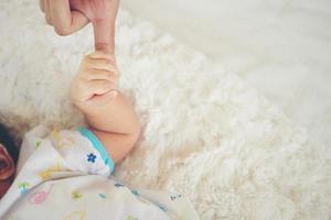 Newborn baby hand on white bed. photo