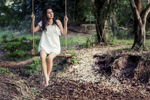 Beautiful woman sitting on swing waiting for someone photo