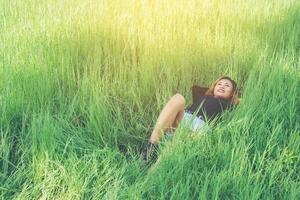 beautiful young woman lying down on green grass enjoying life and happy photo