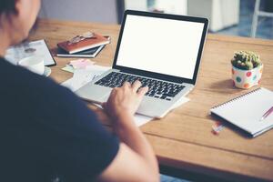 Man's hands typing working with laptop on wooden desk photo