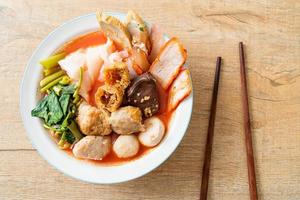 Noodles with meatballs in pink soup or Yen Ta Four Noodles in Asian style photo