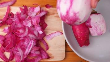 Close in of Woman's Hand Peeling a Red Radish video