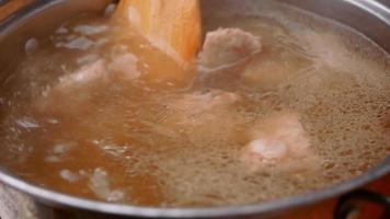 sopa fervida com costela de porco em uma panela no fogão elétrico video