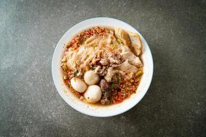 Noodles with pork and meatballs in spicy soup or Tom yum noodles in Asian style photo