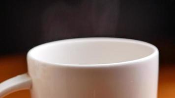 vapor blanco gira y se eleva de una taza de café caliente