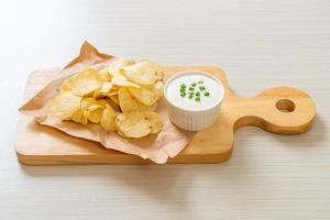 Potato chips with sour cream dipping sauce photo