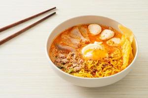 Egg noodles with pork and meatball in spicy soup or Tom Yum Noodles in Asian style photo