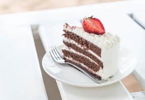 Vanilla and chocolate cake with strawberry in cafe photo