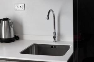 Clean stainless steel sink. small kitchen counter in the apartment. photo