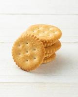 Rounded Cracker cookies on white wooden table background photo