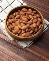 Almonds in wooden bowl on the table, Healthy snack, Vegetarian food photo