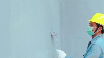 close-up de um homem com luvas segurando um rolo de pintura video