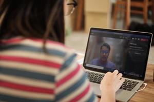 Asian woman using laptop for work from home and online meeting. photo