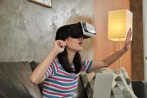 mujer asiática con auriculares vr, viendo la simulación virtual 3d. foto