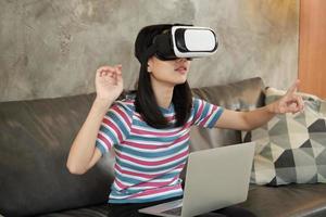 mujer asiática con auriculares vr, viendo la simulación virtual 3d. foto