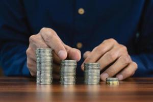 Hand counting coins stack on wooden table photo