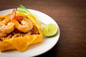 Thai stir fried noodles with shrimps and egg wrap photo