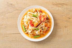 Som Tum - Thai Spicy green papaya salad with salty eggs photo