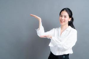 Asian woman with hand presenting on side photo