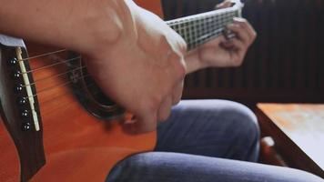 Musician playing the guitar at home video