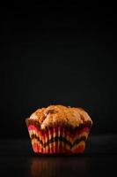 Muffin on a black background. Sweet homemade raisin cake. photo