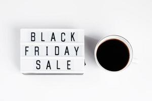 Black Friday concept. Cup of coffee and lightbox on white background. photo