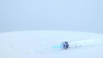 Arzt in blauen Handschuhen nimmt Glasfläschchen und Spritze mit Impfstoff auf.