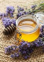 Jar with honey and fresh lavender flowers photo