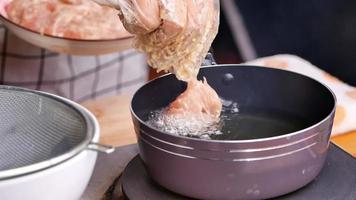 la donna in guanti sta friggendo il pollo marinato video