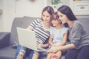 Mother, Aunt and kid having time together lerning with using laptop photo