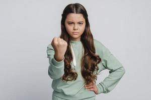 Angry girl shows fist, looks menacingly at the camera