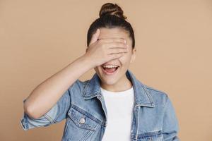 Cheerful, sweet girl closed her eyes with her hand photo