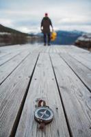 Brújula antigua sobre un fondo de madera con una figura humana foto