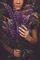 Woman holding a bouquet of lupine flowers photo