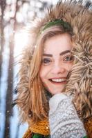Retrato de invierno de una hermosa niña con sombrero y guantes foto