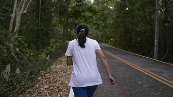 L'arrière du coureur féminin jogging dans la forêt