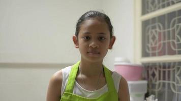 glad kvinnlig tonårskock med köksredskap hemma video
