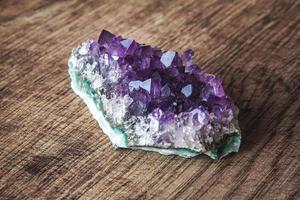 Cristal de amatista púrpura sobre un fondo de madera foto