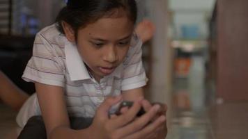 Female Teenager Lying on The Floor Watching Video from Smartphone