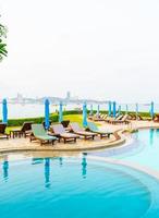 Piscina de silla o piscina de cama y sombrilla alrededor de la piscina con fondo de playa de mar en Pattaya en Tailandia foto